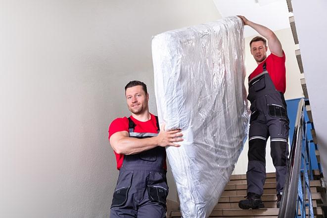 team of workers lifting a box spring out of a house in Aumsville